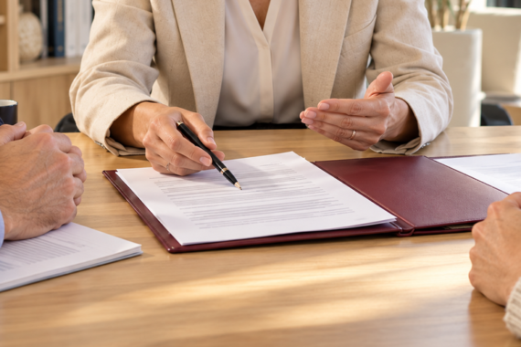 Abogada asesora a una pareja sobre el convenio regulador de un divorcio ante notario, con atención a los documentos sobre la mesa. Martínez y Pulido Abogados, despacho en Vecindario, Gran Canaria.