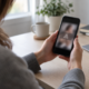 Persona revisando en su teléfono una alerta por la difusión de fotos íntimas sin consentimiento.